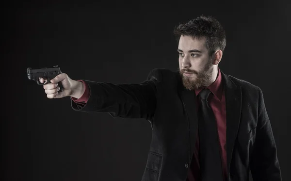 Young Man in Black Suit Aiming a Gun — Stock Photo, Image