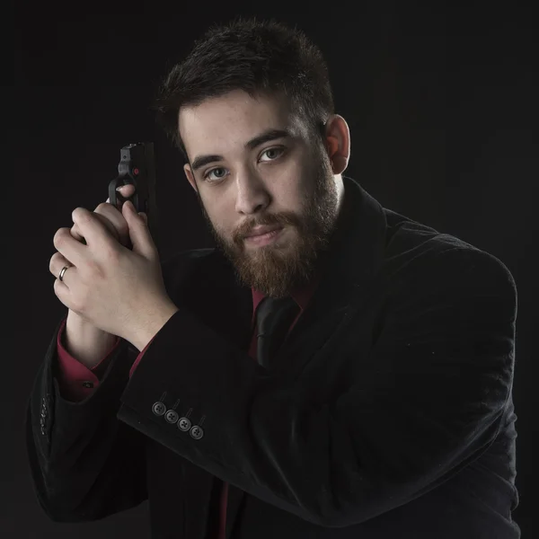 Jovem agente no preto terno segurando pistola — Fotografia de Stock