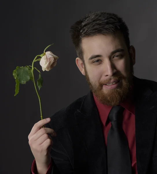 Ler stilig bockskägg Man håller vissnade Rose — Stockfoto