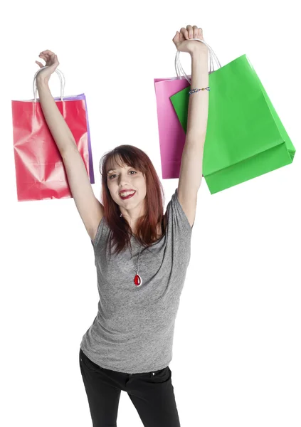 Jeune femme tenant des sacs à provisions colorés — Photo