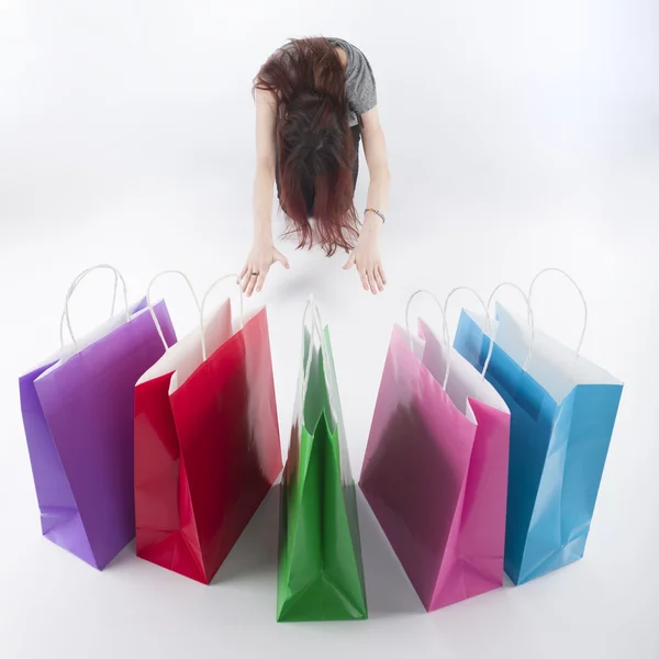 Woman Bowing on Floor In Front of Shopping Bags — Stock Photo, Image