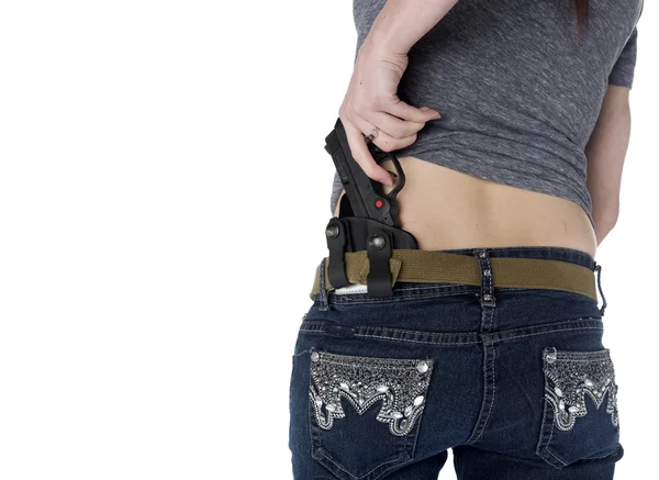 Frau legt Handfeuerwaffe auf ihr Hüftholster — Stockfoto