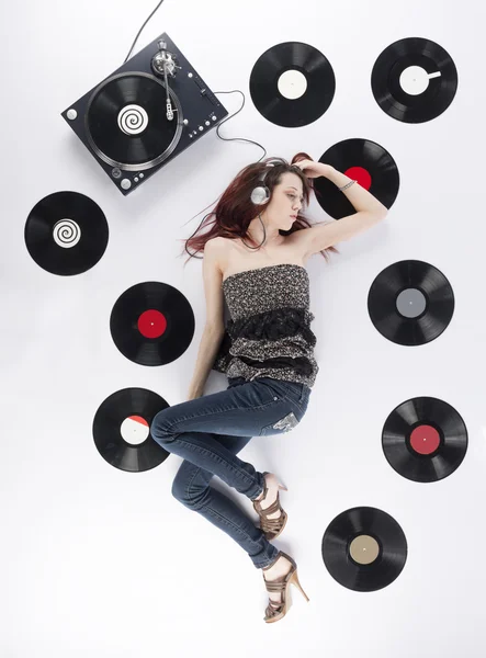 Mujer joven descansando en el suelo escuchando música — Foto de Stock