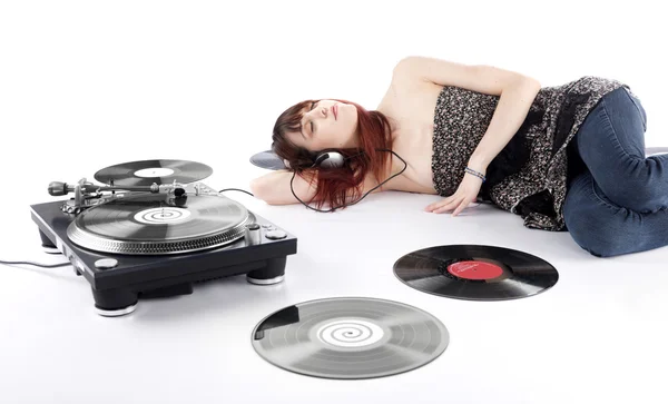 Jeune femme allongée sur le sol Écouter de la musique Image En Vente