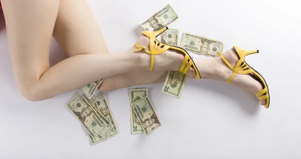 Sexy žena nohy na podlaze s námi dolarů — Stock fotografie