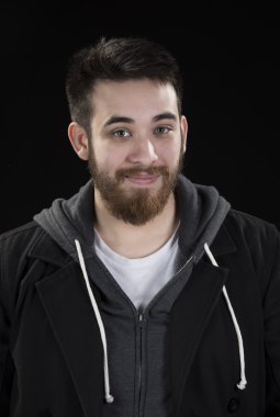 Top sakallı genç adam kameraya bakarak ceketli