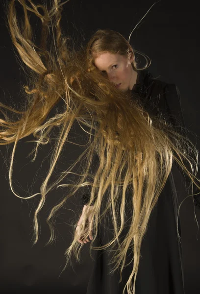 Blonde Frau mit Wind, der durch lange Haare weht — Stockfoto