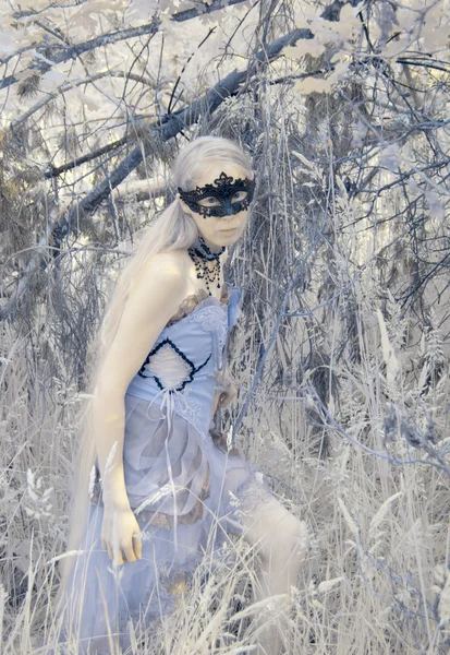 Мифическая женщина в маске и платье в лесу — стоковое фото