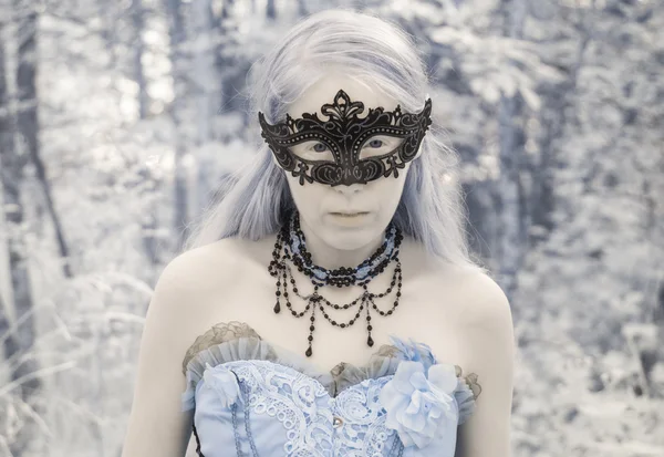 Мифическая женщина в маске и платье в лесу — стоковое фото