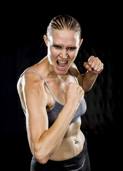 Angry Female Fighter in Combat Pose Against Black — Zdjęcie stockowe