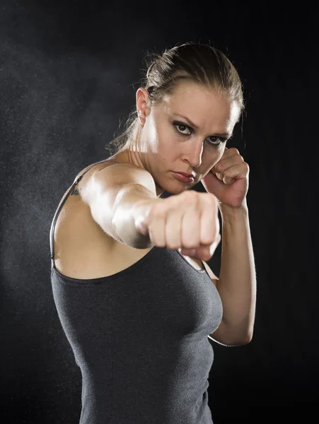 Female Fighter in Combat Pose Against Black — Stock fotografie