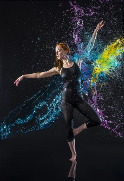 Dançarina feminina sendo salpicada com água colorida — Fotografia de Stock