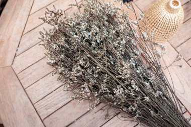 Duvarda kurumuş çiçekler asılı.