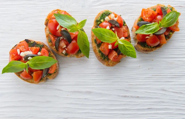 Bruschetta di pomodoro italiano con verdure tritate, erbe aromatiche e olio — Foto Stock