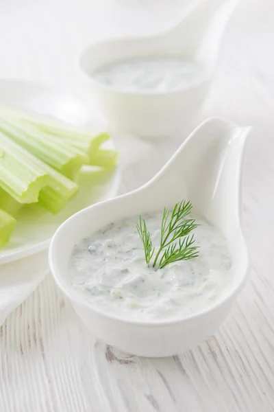 Palitos de apio fresco con salsa de yogur sobre fondo de madera blanca —  Fotos de Stock