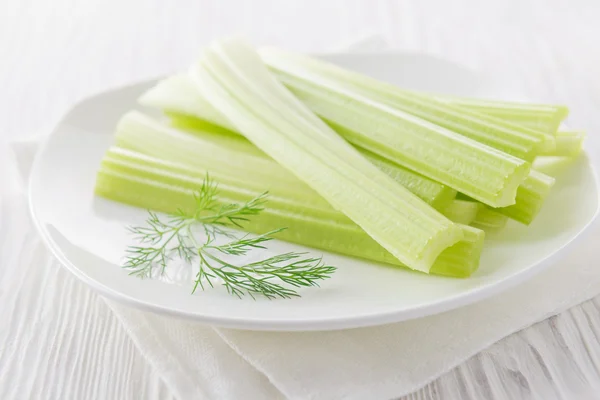 Palitos de apio fresco con salsa de yogur sobre fondo de madera blanca — Foto de Stock