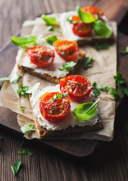 Toasts (Crostini) with ricotta and cherry tomatoes Stock Image