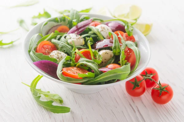 Salada vegetariana com tomate cereja, mussarela e rúcula Fotografia De Stock