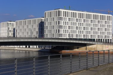 Spree 'de ön planda parmaklıkları olan üç beyaz ofis kulesi.