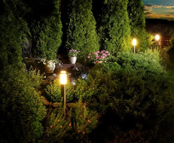 Pátio iluminado jardim em casa ao anoitecer — Fotografia de Stock