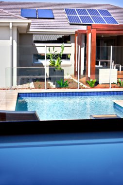 Modern bir yüzme havuzu ve bir ev güneş panelleri o ile bir görünüm
