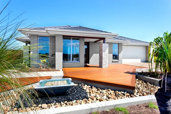 Modern house with trees and stone decoration items including a s — Stock Photo, Image