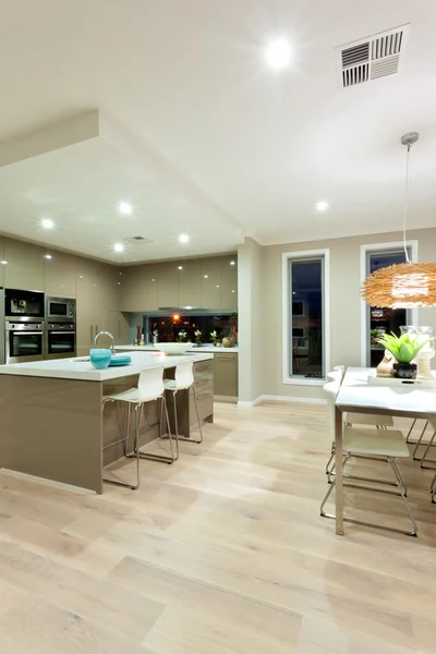 Vista interior de una casa con suelo de madera y cocina al lado de t —  Fotos de Stock