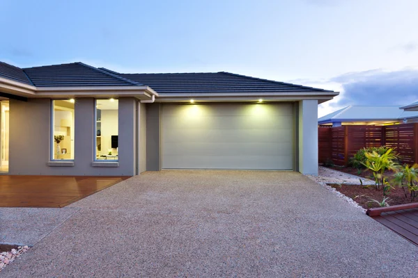 Garage met een lang en breed beton of stenen tuin vooraan bij d — Stockfoto