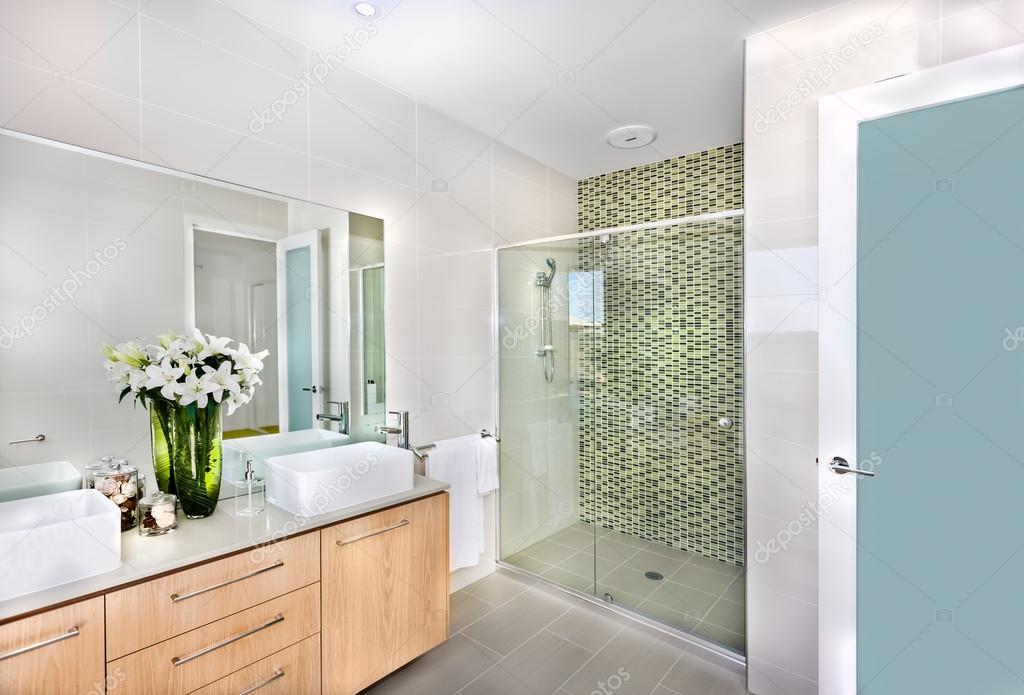 A modern bathroom with white flowers in the vase