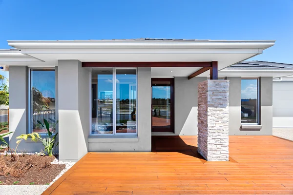 Exterior de uma casa moderna com um piso de madeira com céu azul — Fotografia de Stock