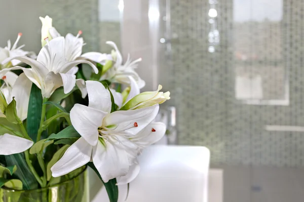 Bando de flores brancas no copo de uma sala com backg borrado — Fotografia de Stock