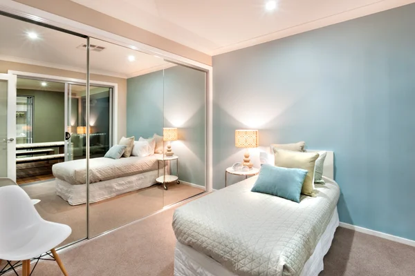 Маленькая спальня с подушками на односпальной кровати и включенным светом — стоковое фото