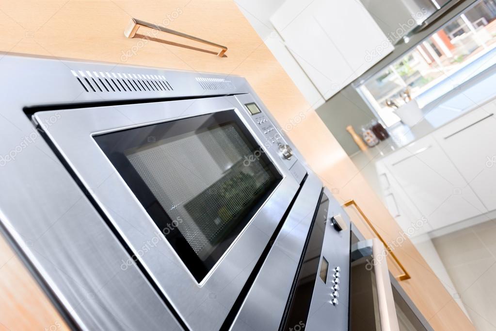 Closeup of a modern oven in a luxury kitchen fixed to the wooden