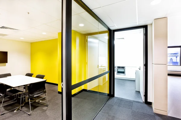 Sala de reuniões com paredes amarelas e corredor e luzes — Fotografia de Stock