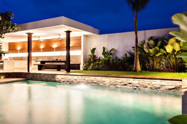 Geceleri şık bir yüzme havuzu ile modern ev 