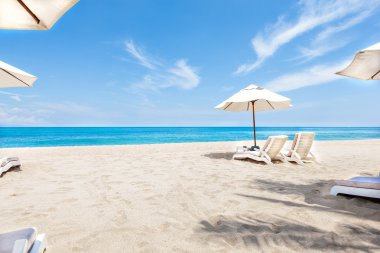 Ocean side sandalye ve şemsiye mavi gökyüzü ile 