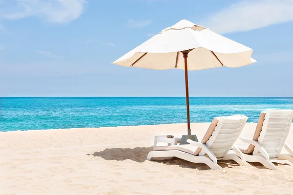 Sedie da spiaggia e ombrelloni sulla sabbia vicino all'acqua — Foto Stock