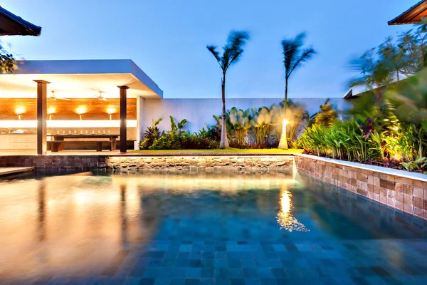 Moderna piscina está iluminada con luces por la noche — Foto de Stock