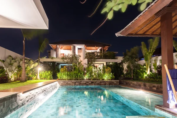 Casa moderna que incluye una piscina en el centro por la noche — Foto de Stock