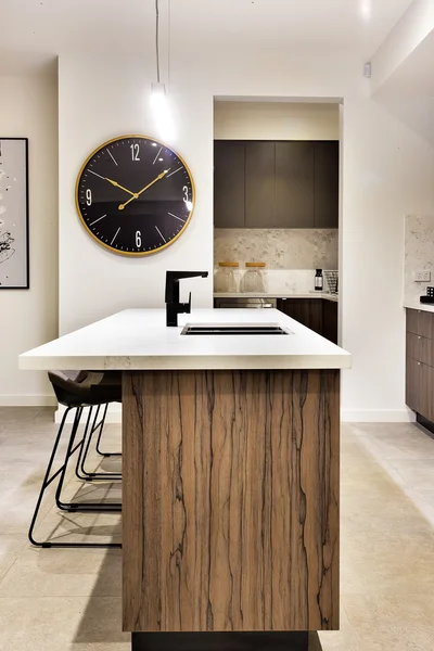 Bancada de cozinha moderna com um relógio de parede e cadeiras — Fotografia de Stock