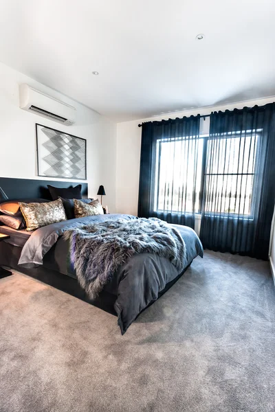Современная спальня с ковровым покрытием, освещённым солнцем — стоковое фото
