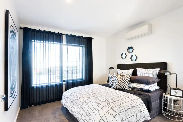Nowoczesna sypialnia oświetlony blaskiem przez kurtynę — Zdjęcie stockowe