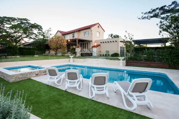 Moderna piscina frente a la casa con césped — Foto de Stock