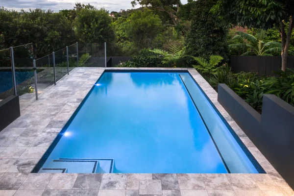 Luksusowy basen zbliżenie z błękitną wodą obok lasu — Zdjęcie stockowe