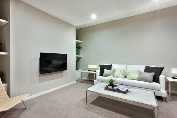 Salón con una mesa blanca y sofás con almohadas de lujo — Foto de Stock