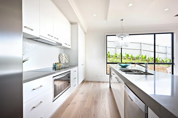 Keuken tegenbovenkant met houten vloer naast een venster — Stockfoto