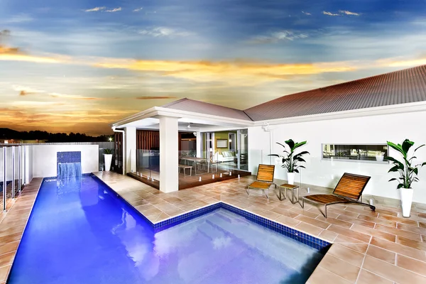 Современный дом или отель с бассейном с голубой водой — стоковое фото