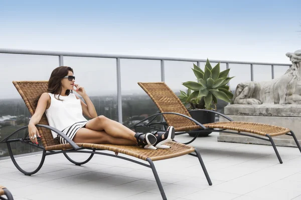 Morena en una mini falda relajándose en una terraza —  Fotos de Stock