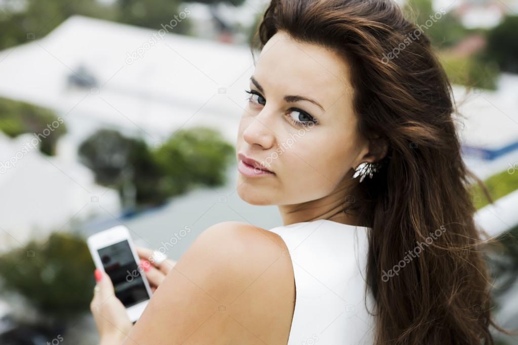 Woman with natural makeup holding a smartphone