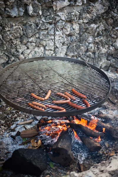 Kiełbasy gotowane są powyżej ognia — Zdjęcie stockowe